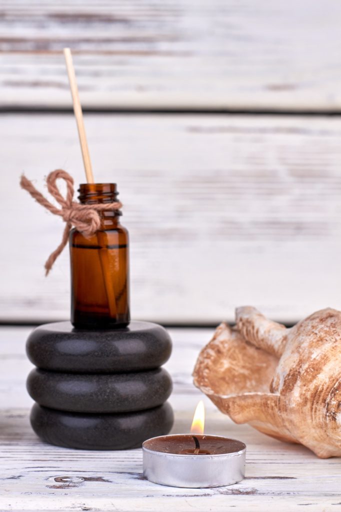 Bottle of oil with stones and seashell for spa therapy.